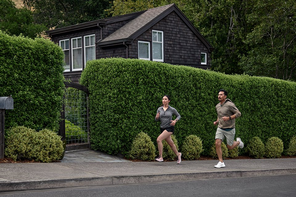 Two people running on a pavement wearing Vivoactive® 5 GPS smartwatches. 