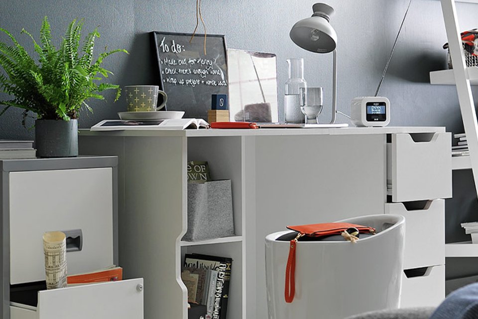 Pierre Henry 2 drawer metal filing cabinet in silver and white placed in a home office next to a white desk. 