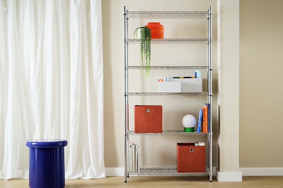Argos Home metal 6 tier shelving unit with red storage boxes, plants, books, vase and other ornaments placed on it. 