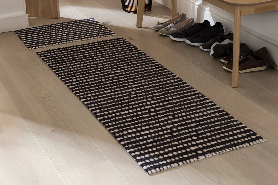 A Habitat washable black and white runner and mat set in a hallway.