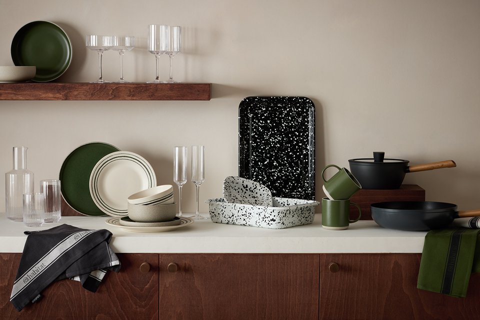 Habitat Splatter Enamel pie dish, baking tray and other dinnerware and glassware sets displayed on a white kitchen counter. 