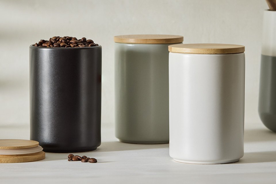 A set of 3 Habitat matte finish ceramic storage canisters in black, grey, and white. 