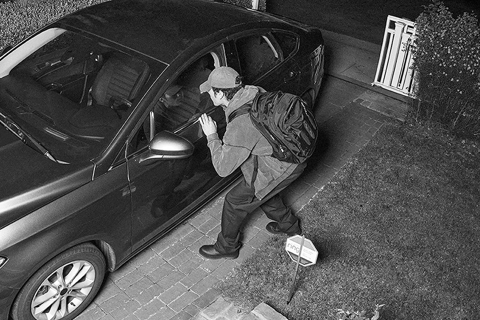 Someone getting in the car shown through a Ring security camera.