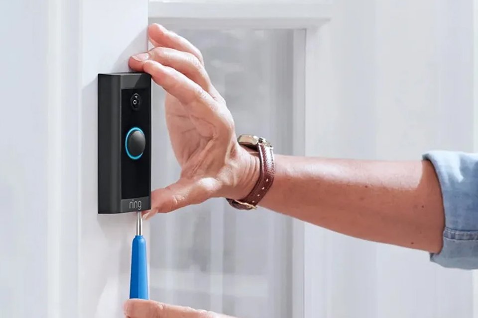 Someone installing a Ring video doorbell.
