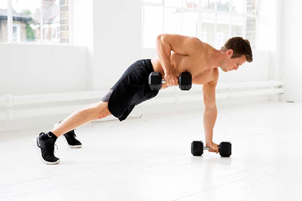 A man doing a renegade row with black dumbbells.