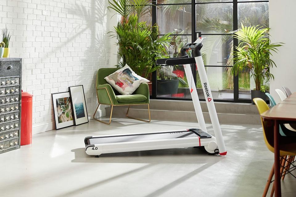 A Reebok Run 4.0 treadmill in a home gym.