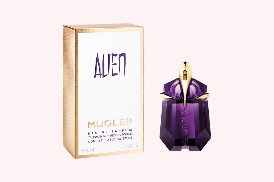 A bottle of Thierry Mugler Alien Eau de Parfum with a light pink background.