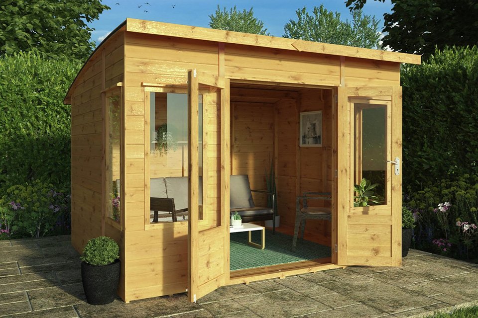 Wooden summer house in garden with glass doors.