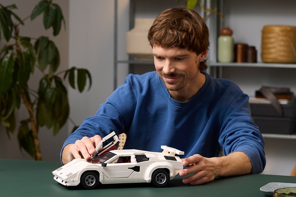 Man playing with the LEGO® Icons Lamborghini Countach 5000 Quattrovalvole.