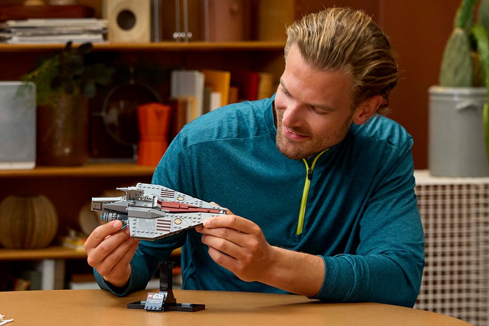 Man playing with the LEGO® Star Wars Acclamator-Class Assault Ship Model set.