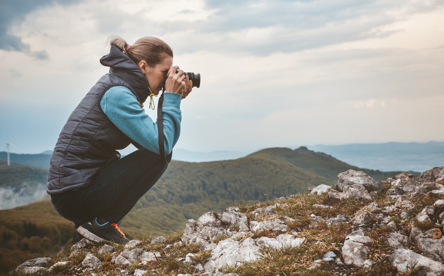 A person clicking a picture of the scenery from a mountain top.