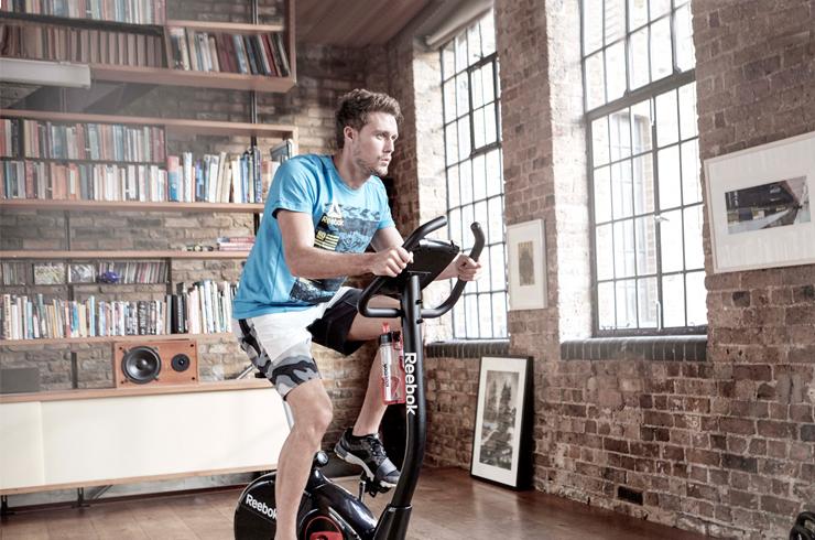 A man working out on an exercise bike in a room.