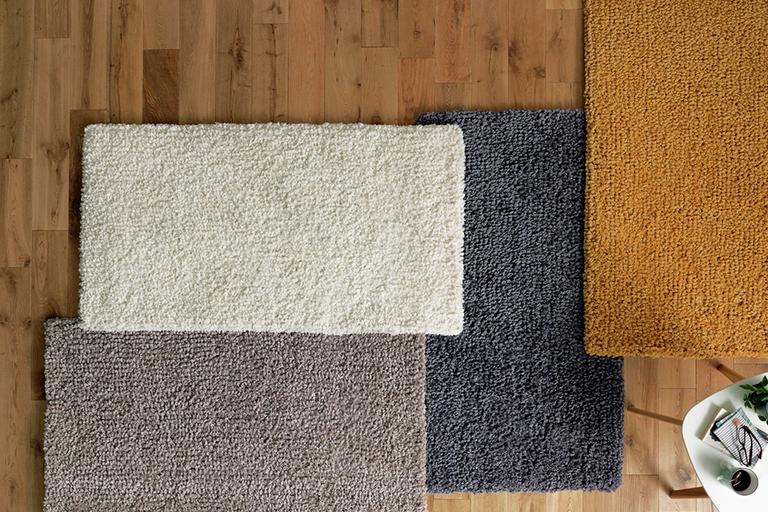 A selection of rugs - cream, grey, mustard and natural.