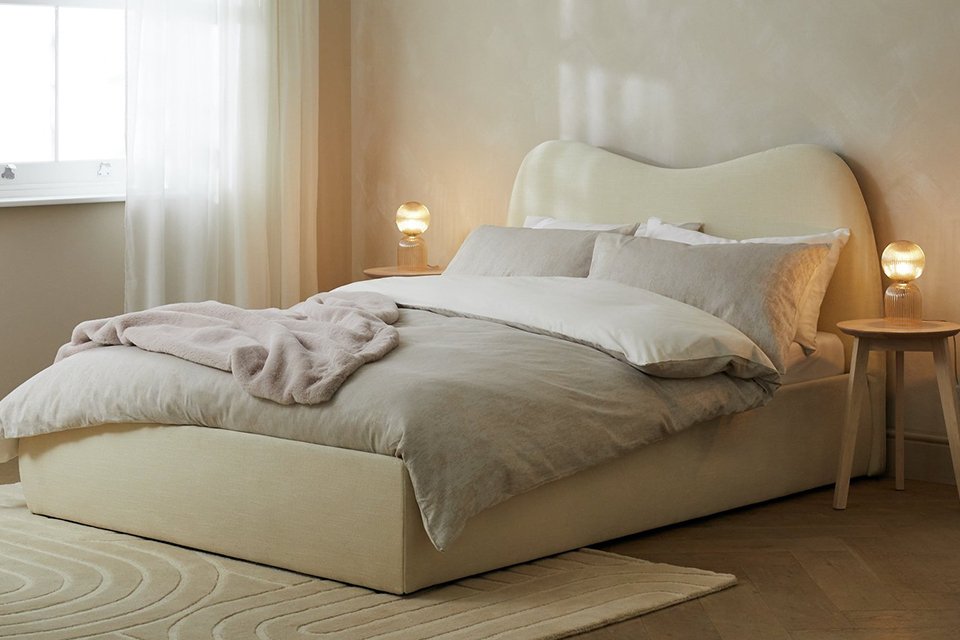 Cream bedding with white underside on bed with cream boucle bedroom.