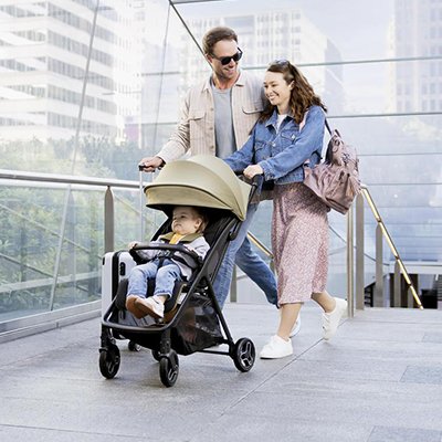 Parents walking with their baby in a stroller.