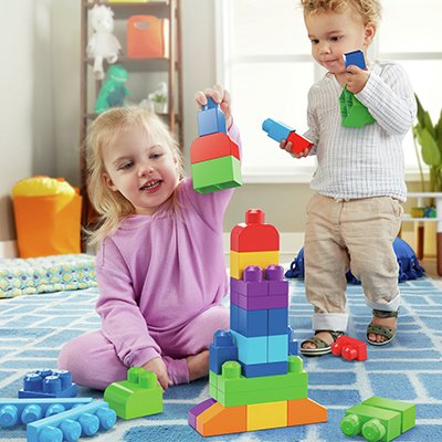 Two kids playing with a colourful blocks set.