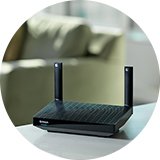 A wifi router on a table in a living room.