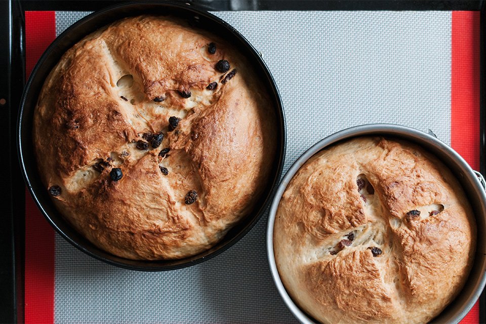 A pair of round bread loaves in round spring form cake tins.