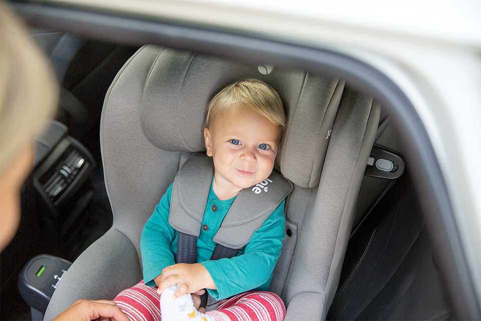 A baby in Joie i-Spin 360™ car seat being swivelled towards mum for easy ins and outs.