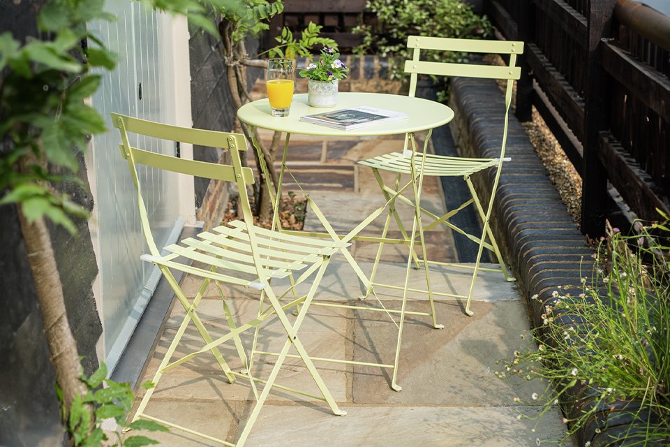 Small outdoor bistro dining set in a garden.