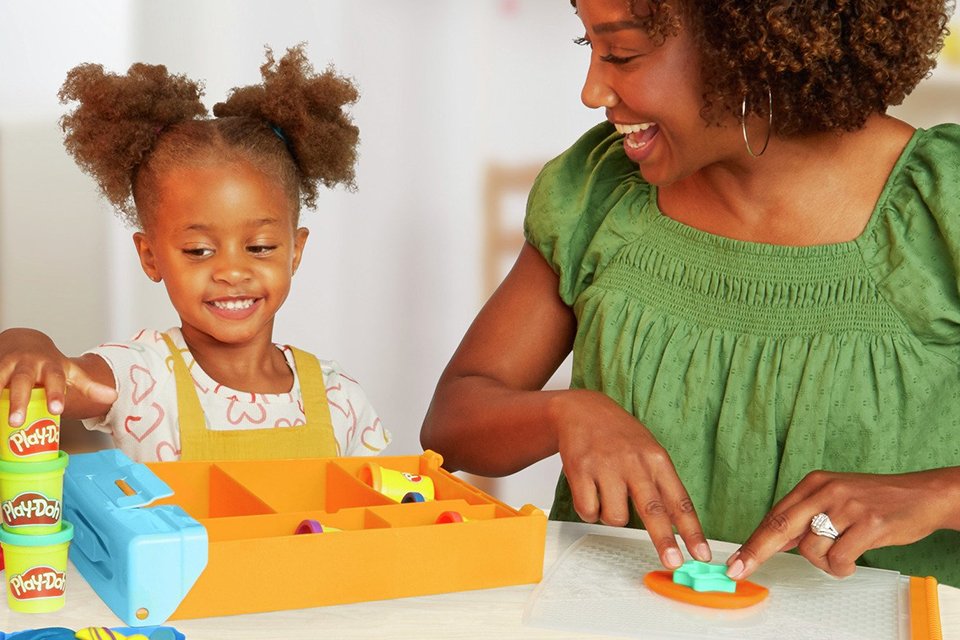 A mother and daughter playing with a Play-Doh Rainbow Animal Storage set with 8 tubs.