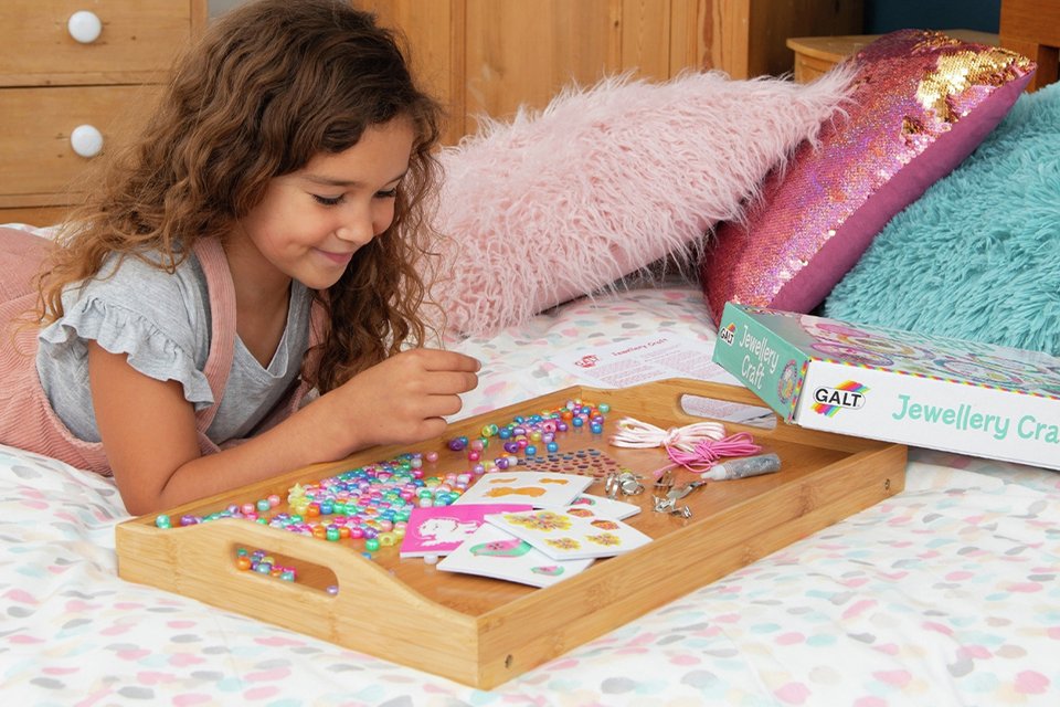 A girl playing with a Galt Jewellery Craft Kit.