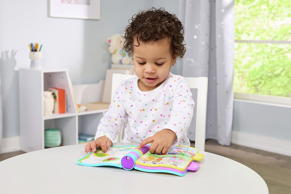 A girl playing with Vtech Peppa Pig Nursery Rhymes book.