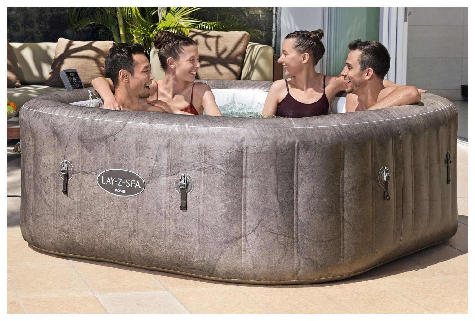 A group of friends sitting in a Lay-Z-Spa Rome 7 Person AirJet Hot Tub placed outdoors. 