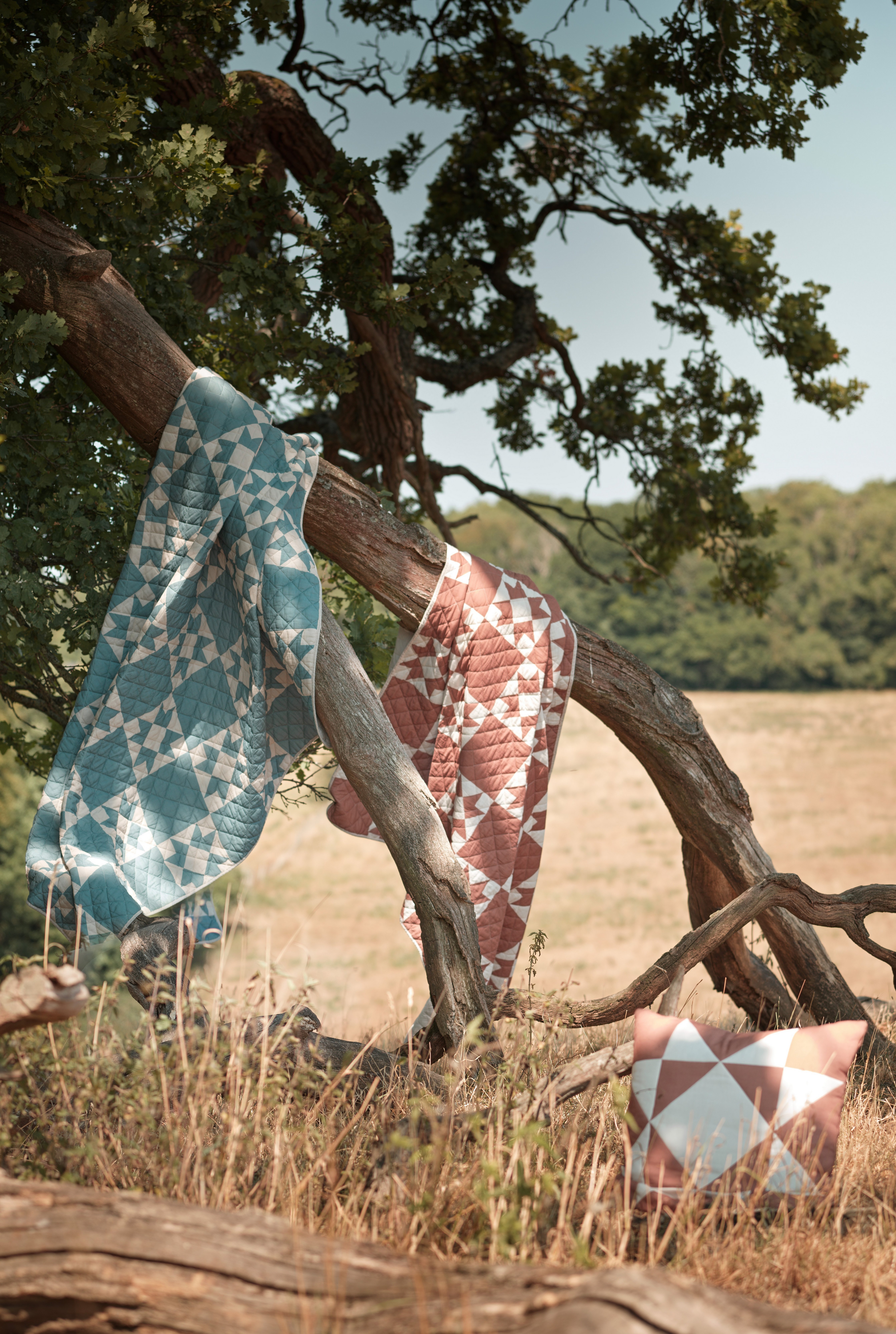 quilted throws on tree in field blowing in wind 