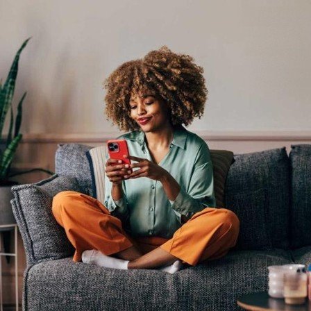 Person using a mobile phone on a sofa