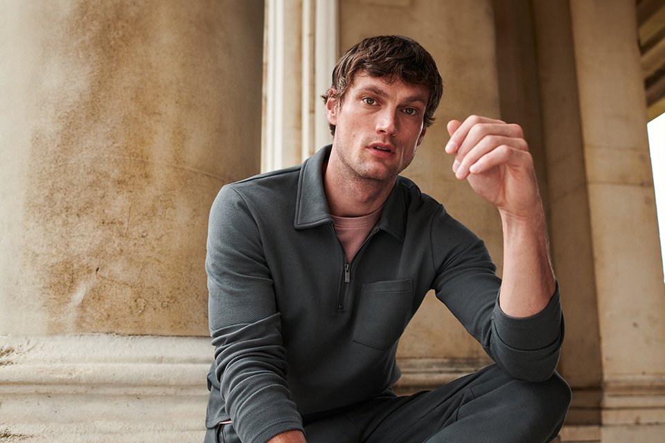 Man in quarter zip hoodie.