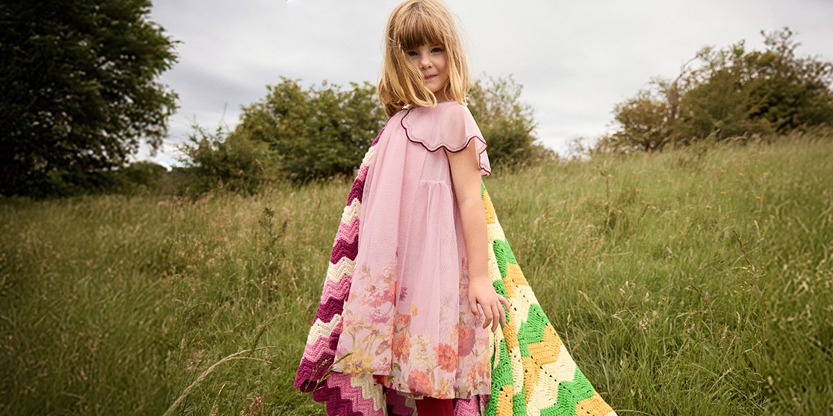 Girl wearing pink Monsoon dress.