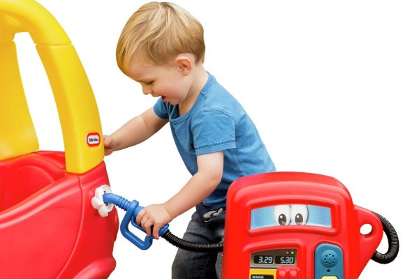 A child filling up their toy car with a toy petrol pump.