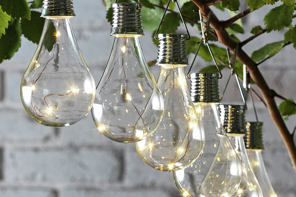Solar lights strung on a tree in a garden.
