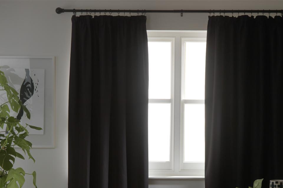 Habitat blackout plain pencil pleat curtains in black colour.