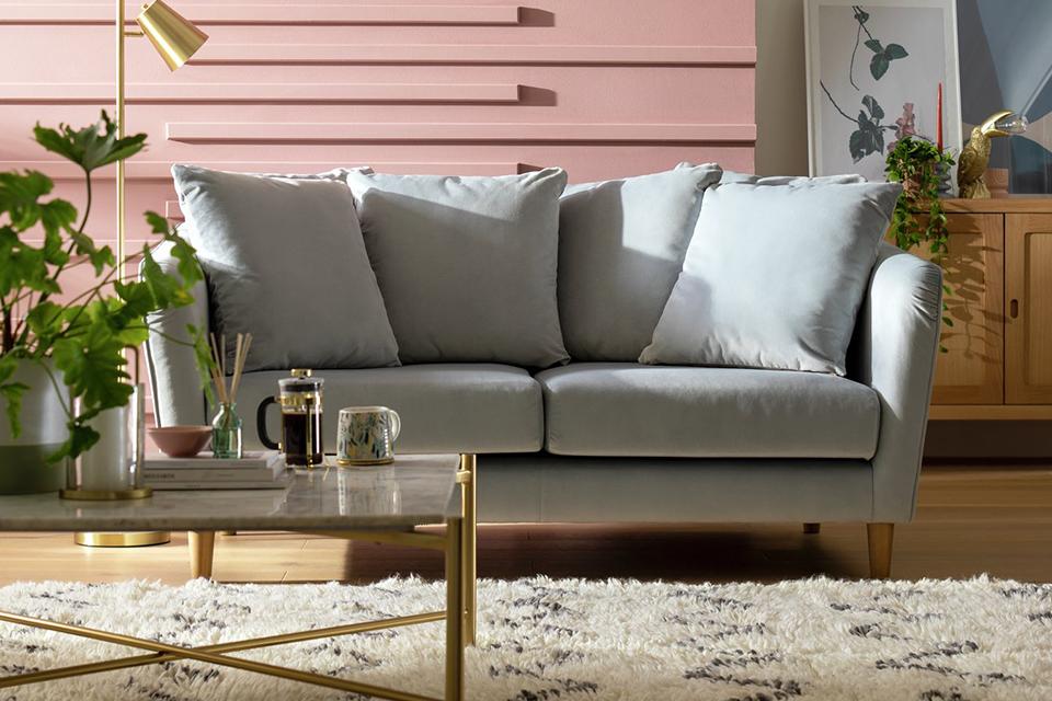 A grey Habitat 2 seater sofa in a pink and white living room.