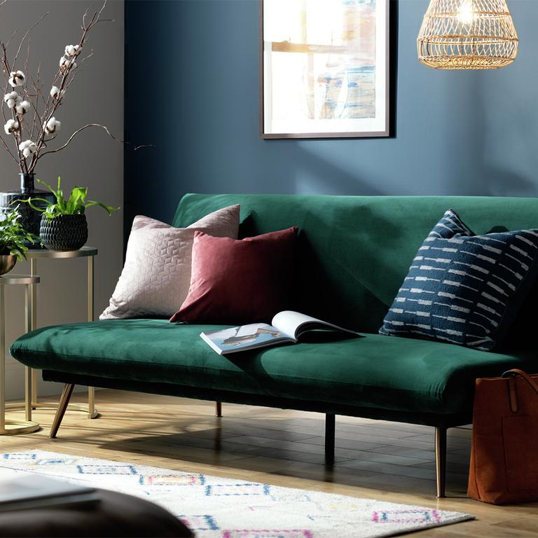 A Habitat Matteo teal velvet sofa bed in a living room.
