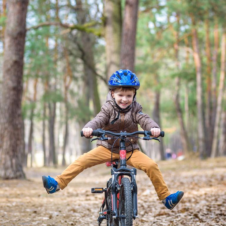 A kid playfully riding his bike.