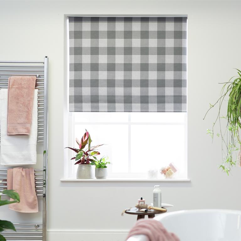 A grey and white checkered blackout blinder on a bathroom window. 