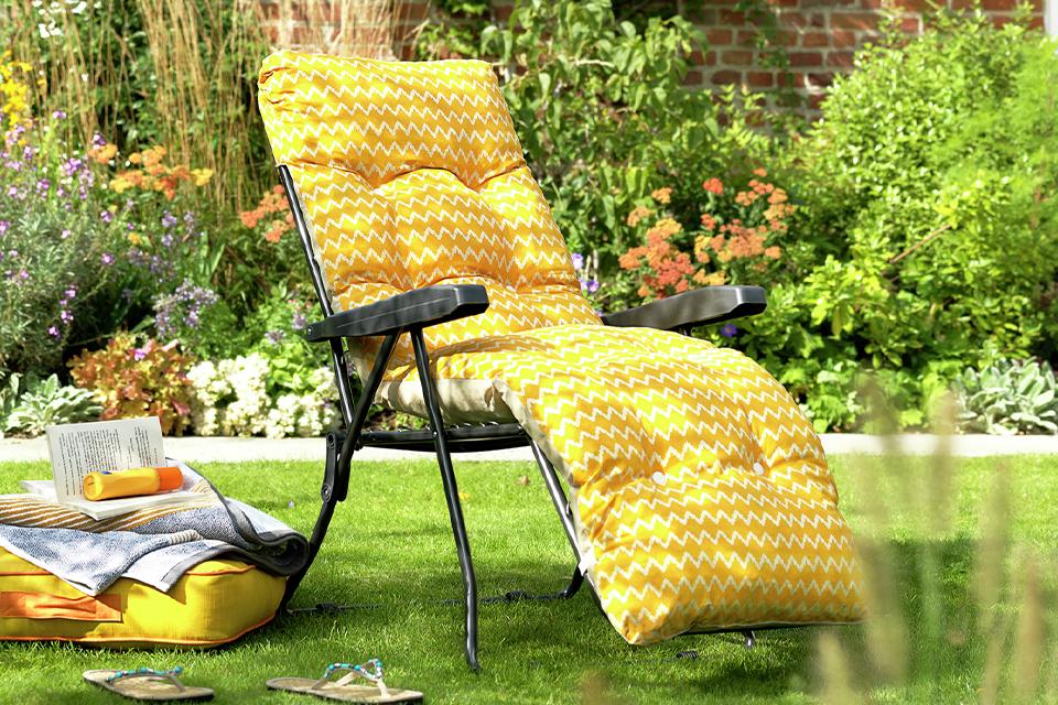 A yellow sun lounger in a garden.