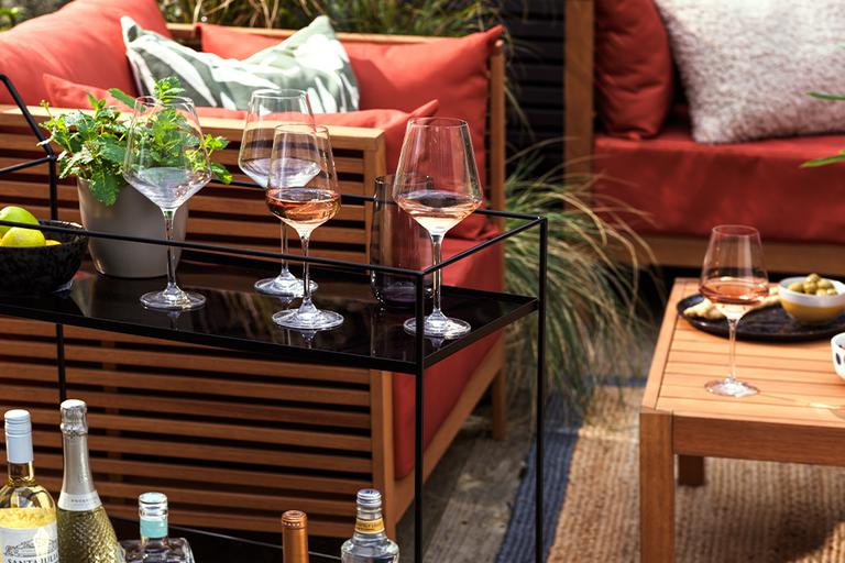 A set of glasses with drinks in a garden.