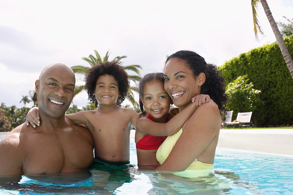A family of four enjoying in the swimming pool.