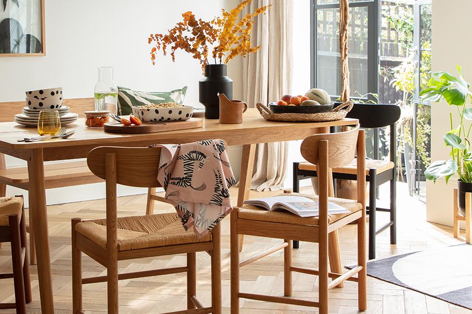 A wooden dining table set with black and white monochrome tableware in brushstroke print.