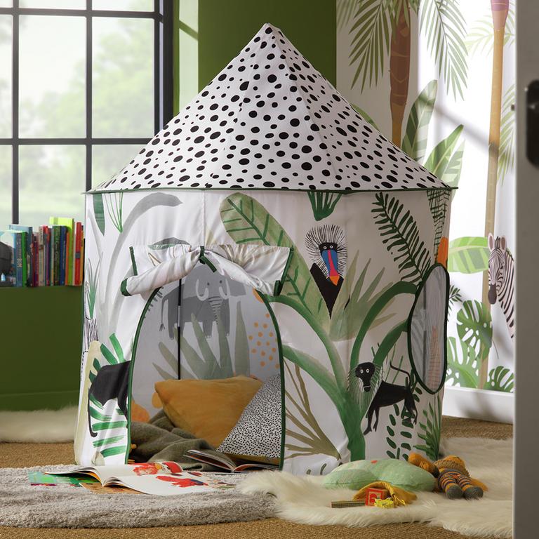 A jungle print play tent on a white faux fur rug in a kid's playroom.