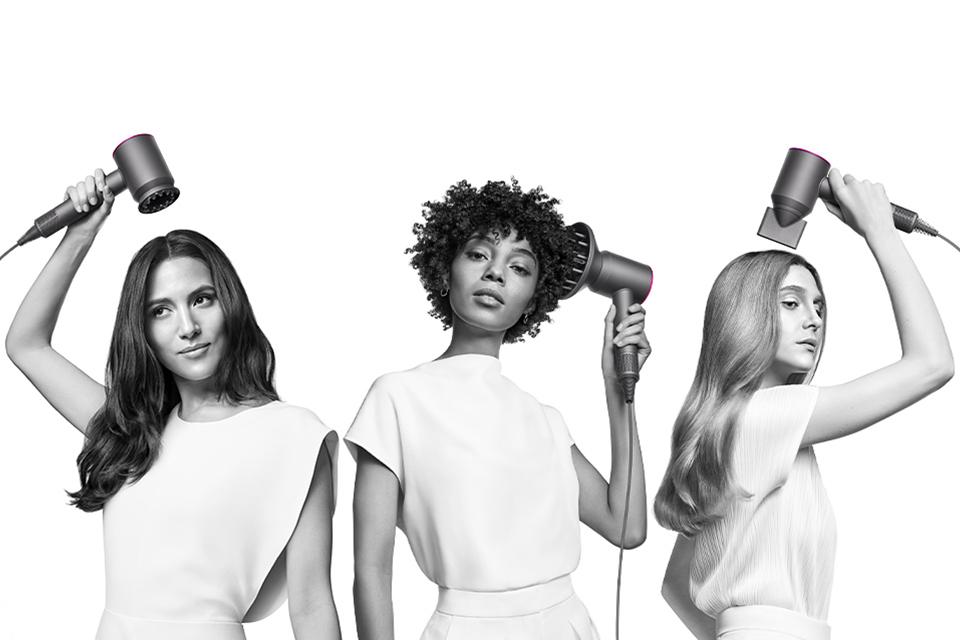 3 girls demonstrating different functions of the Dyson Supersonic hair dryer.