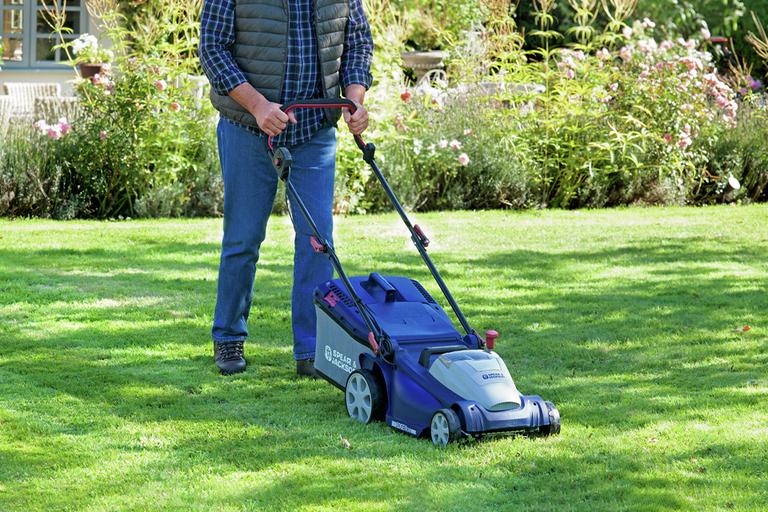 A man using a Spear and Jackson cordless lawnmower.