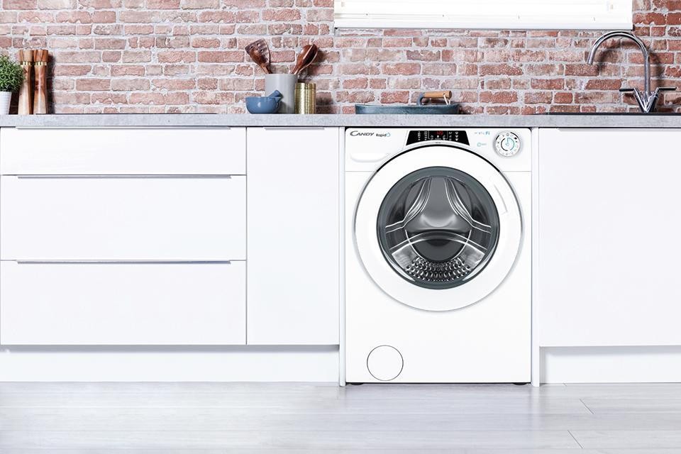 Freestanding washing machine in a white kitchen.