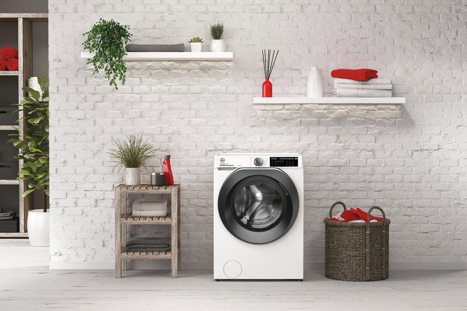 Freestanding washing machine in a white utility room.