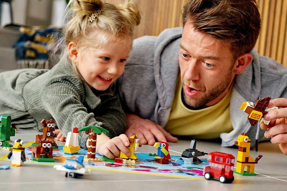 A father and daughter playing with LEGO Classic 4+ Around the World Building Bricks Set 11015.