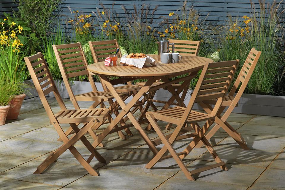 A 6 seater wooden patio set placed outdoors.